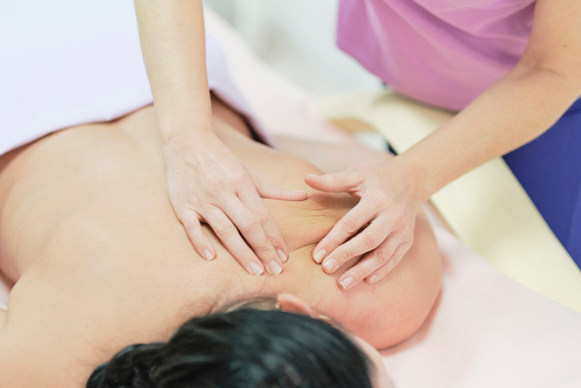 Remedial massage focused on a client’s shoulder and neck